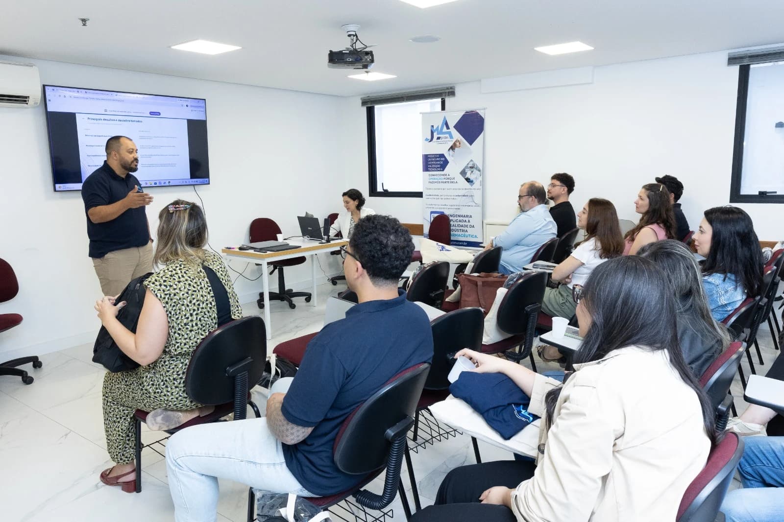 Profissional da JMA Plan apresentando para uma turma